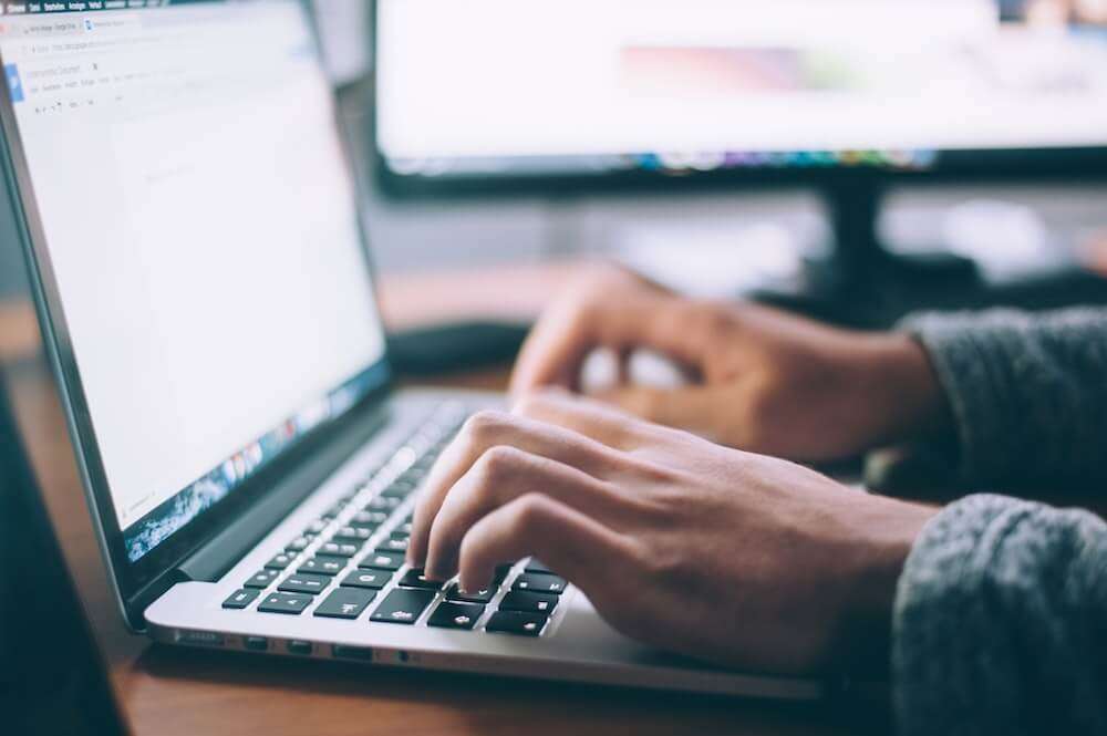 A picture of a person researching products on a computer, with a diverse array of products displayed on the screen. This could represent the process of finding a unique and in-demand product to import from China.